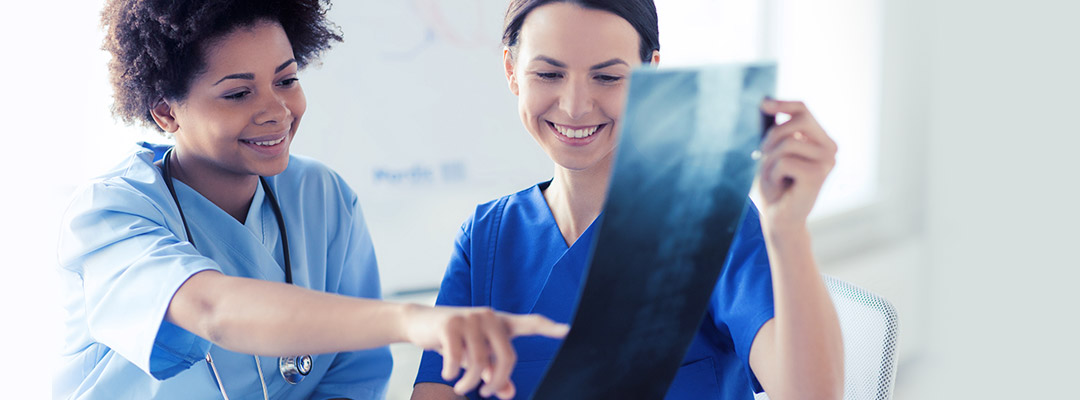 two nurses looking at an xray photo